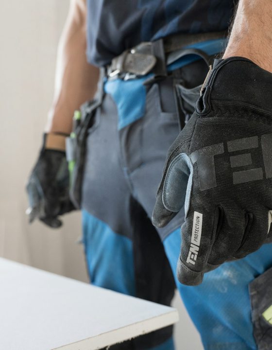 a man wearing a pair of black and blue work gloves